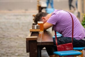 sleeping man at a table next to the beer cup brew craft problem with alcohol