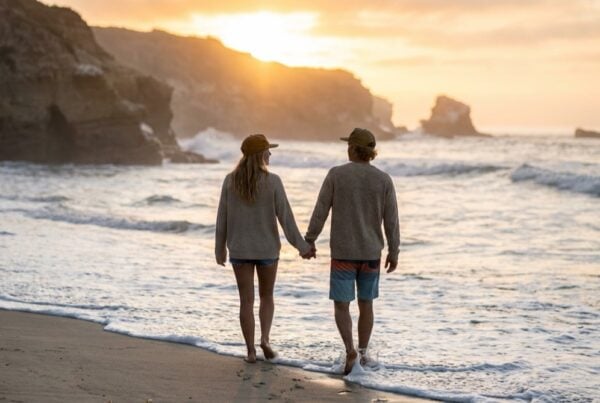 Couple beginning couples detox together, holding hands on the San Diego shoreline at sunrise