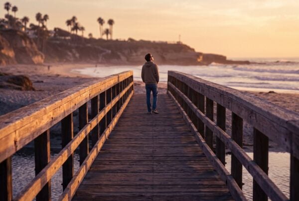 Coastal footbridge crossing toward the La Jolla shoreline at golden hour representing the aftercare bridge after rehab